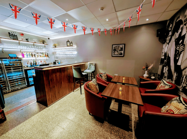 cocktail bar in Ashton-in-Makerfield showcasing the bar area with a serving counter, wine fridges, alcoholic spirits and hanging glassware.